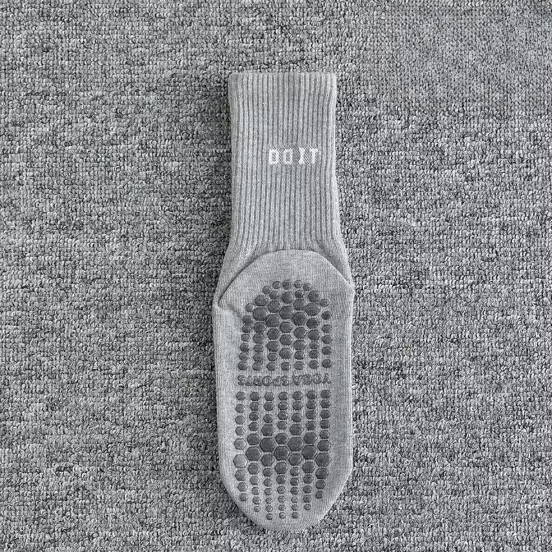 Laden Sie das Bild in Galerie -Viewer, Graue rutschfeste Socke auf Teppichboden, mit Noppen für besseren Halt. Ideal für Yoga, Pilates oder Fitness. Bequem und funktional.
