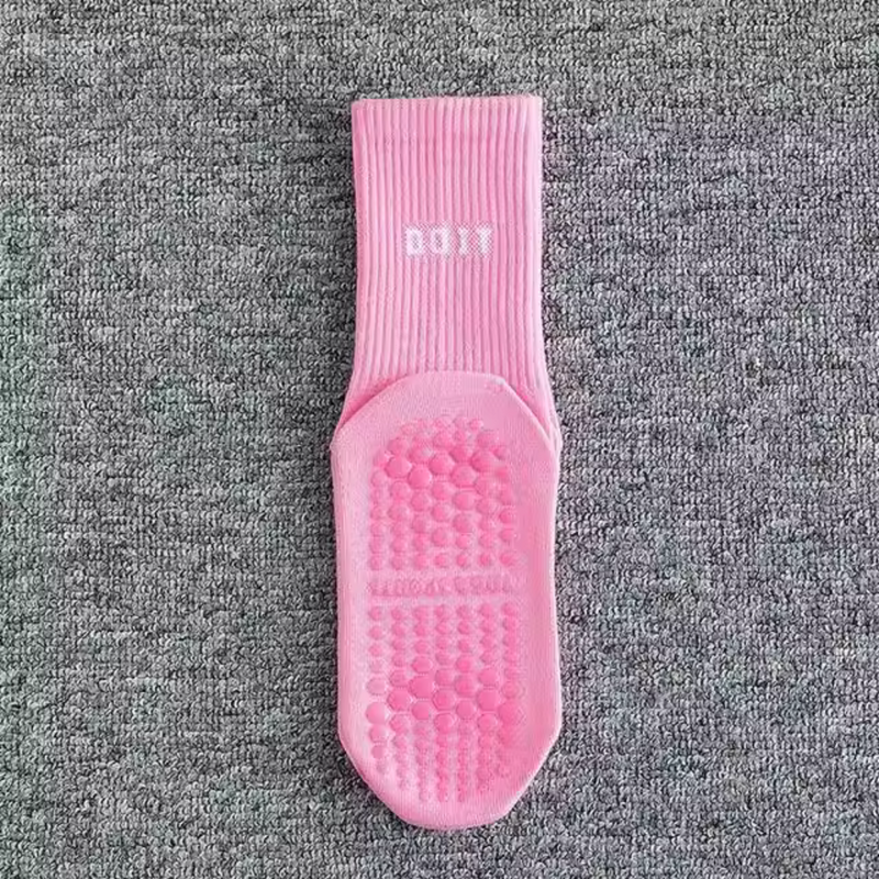Laden Sie das Bild in Galerie -Viewer, Einzelne rosa Anti-Rutsch-Socke auf grauem Hintergrund, mit gepolsterten Noppen für besseren Halt. Ideal für Yoga oder Pilates.
