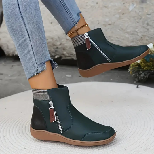 Damenstiefeletten mit Reißverschluss, grün, flache Sohle, kariertes Futter, kombiniert mit blauen Jeans. Modische Herbstschuhe für Frauen.