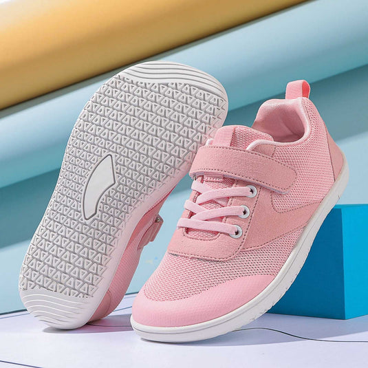 Rosa Kinderschuhe mit Klettverschluss und Gummisohle, ideal für Mädchen. Bequeme, rutschfeste Sneakers auf blauem Hintergrund.